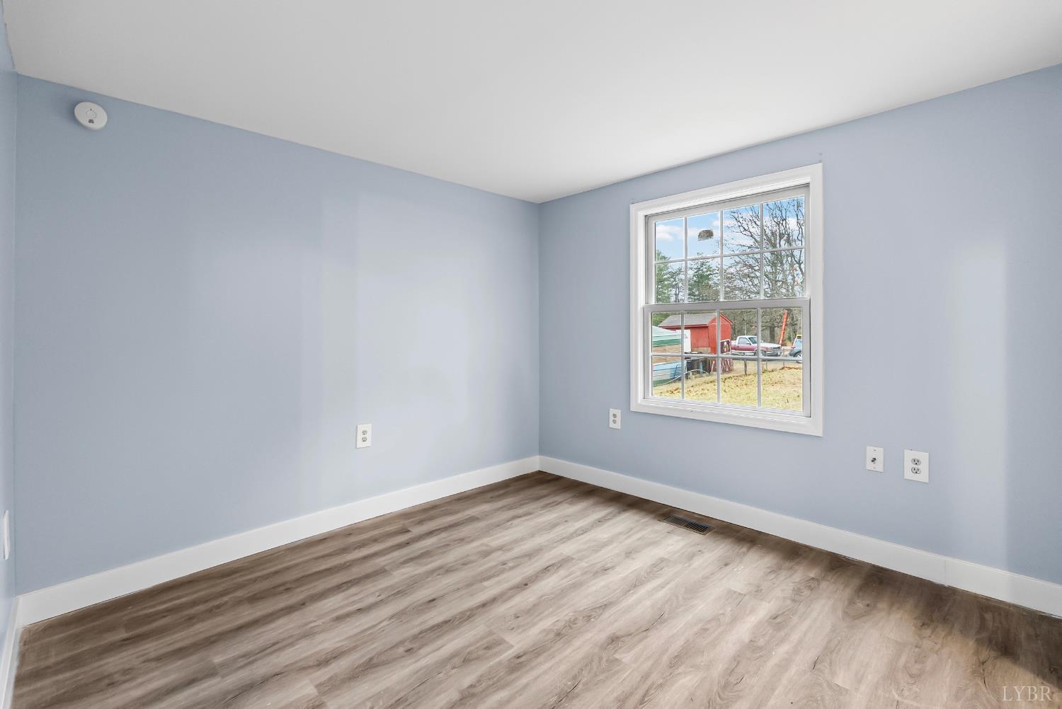 2443 Sunnymeade Road Rustburg, VA 24588 - Photo 22 of 36 a view of an empty room with wooden floor and a window