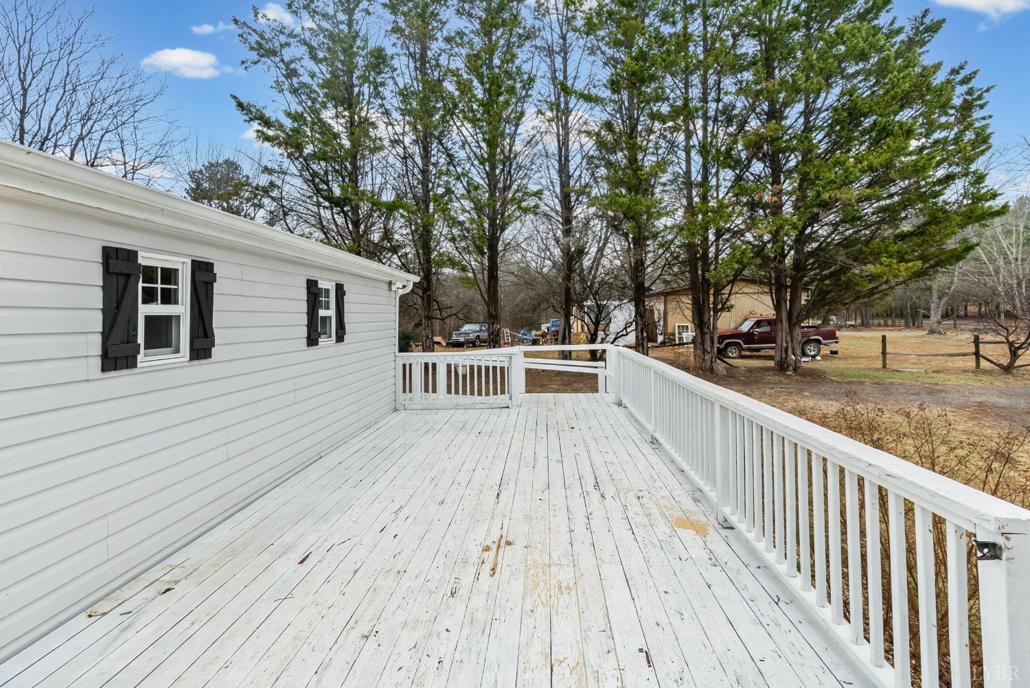 2443 Sunnymeade Road Rustburg, VA 24588 - Photo 26 of 36 a view of a wooden deck and trees with wooden fence