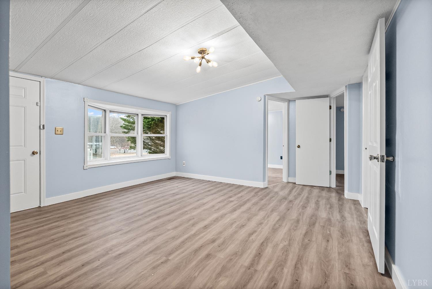 2443 Sunnymeade Road Rustburg, VA 24588 - Photo 6 of 36 a view of an empty room with wooden floor and a window