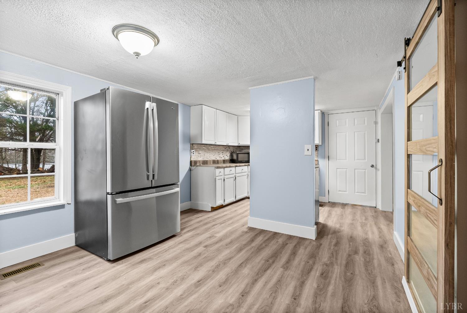 2443 Sunnymeade Road Rustburg, VA 24588 - Photo 7 of 36 a kitchen with kitchen island wooden floors appliances and cabinets