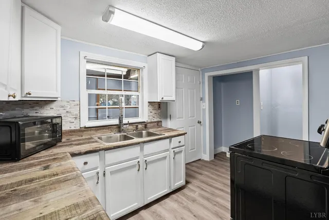 a kitchen with granite countertop a sink stove and cabinets