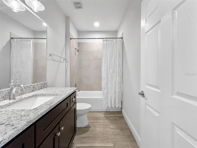 a bathroom with a granite countertop sink toilet and shower