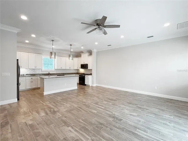 a view of kitchen with granite countertop cabinets and refrigerator