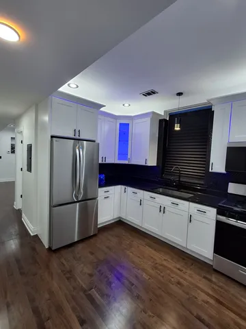 a kitchen with granite countertop a refrigerator and a stove top oven