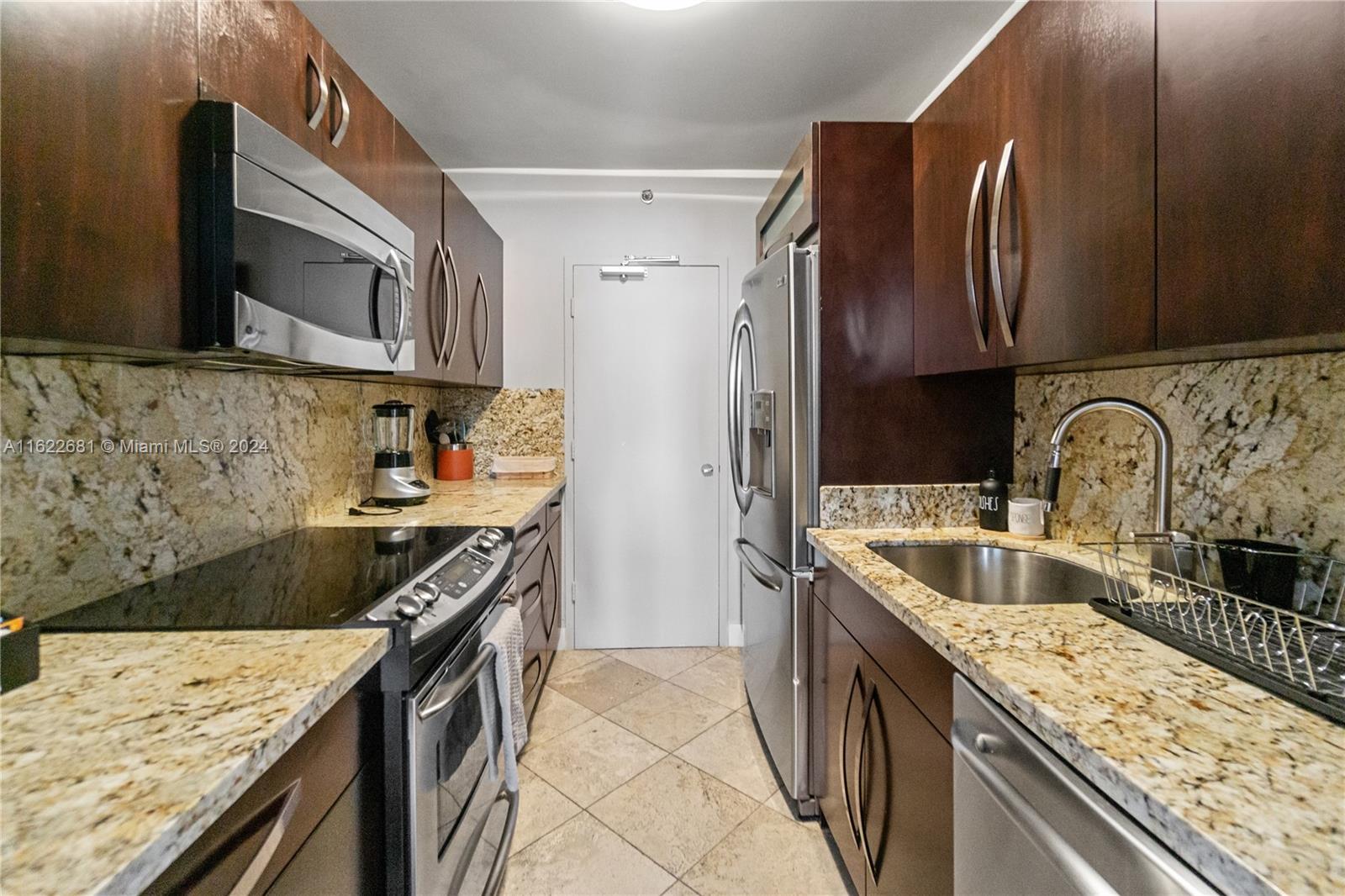 100 Lincoln Road, Unit 1422 Miami Beach, FL 33139 - Photo 16 of 35 a kitchen with stainless steel appliances granite countertop a sink stove and refrigerator