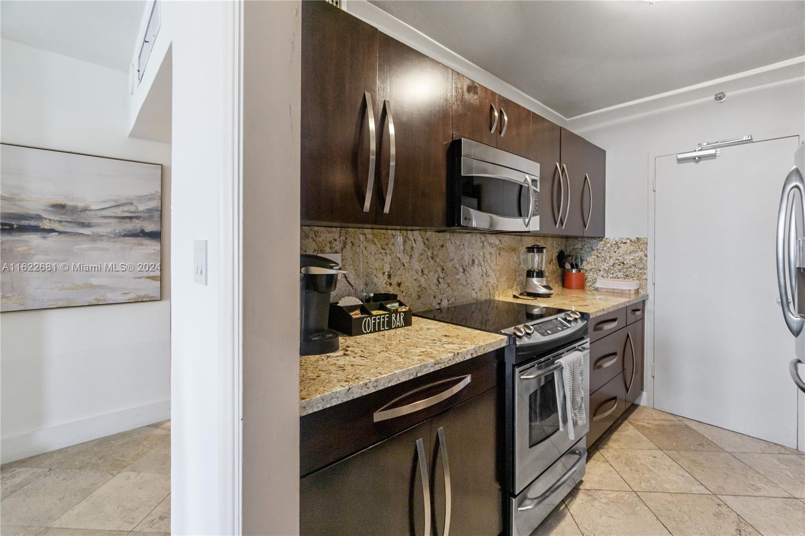 100 Lincoln Road, Unit 1422 Miami Beach, FL 33139 - Photo 17 of 35 a kitchen with stainless steel appliances granite countertop a stove and a refrigerator