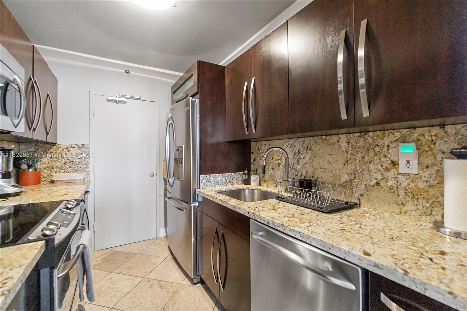 100 Lincoln Road, Unit 1422 Miami Beach, FL 33139 - Photo 18 of 35 a kitchen with stainless steel appliances granite countertop a sink stove and refrigerator