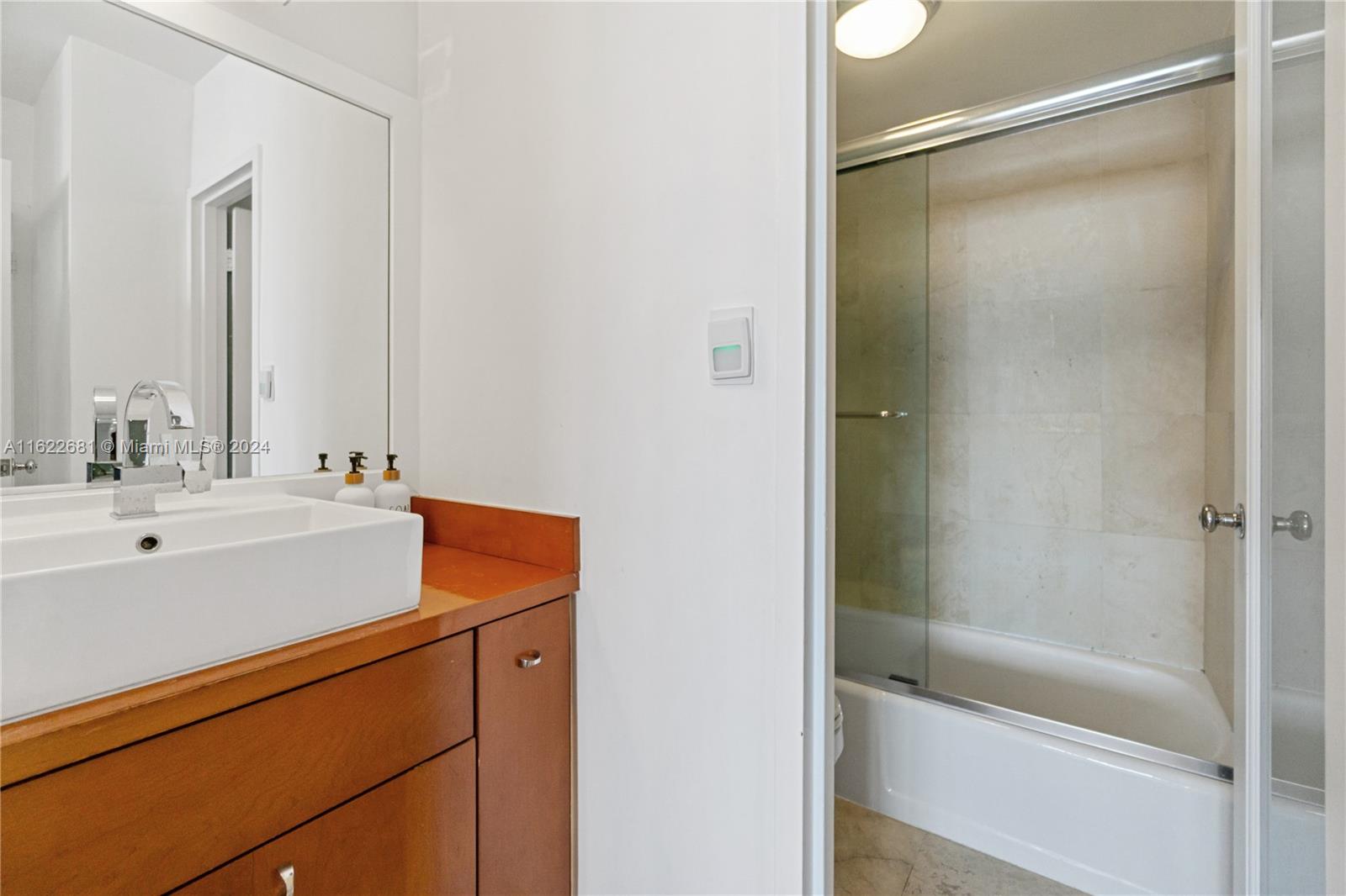100 Lincoln Road, Unit 1422 Miami Beach, FL 33139 - Photo 21 of 35 a bathroom with a shower sink and mirror
