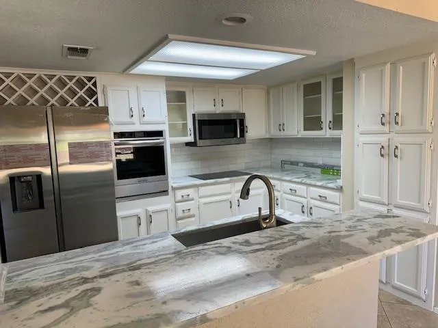 a kitchen with stainless steel appliances granite countertop a sink and a stove