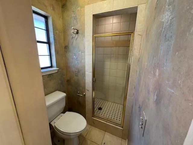 a bathroom with a toilet and a shower