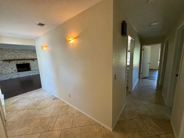 a view of a hallway with wooden floor and a bathroom