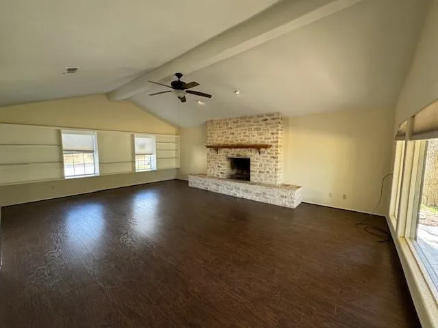 an empty room with windows and fireplace