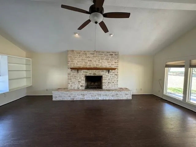 a view of an empty room with a fireplace and a window