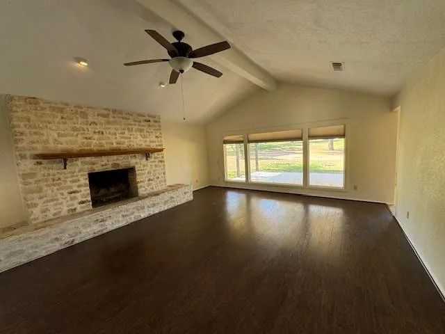 a view of empty room with wooden floor and fireplace