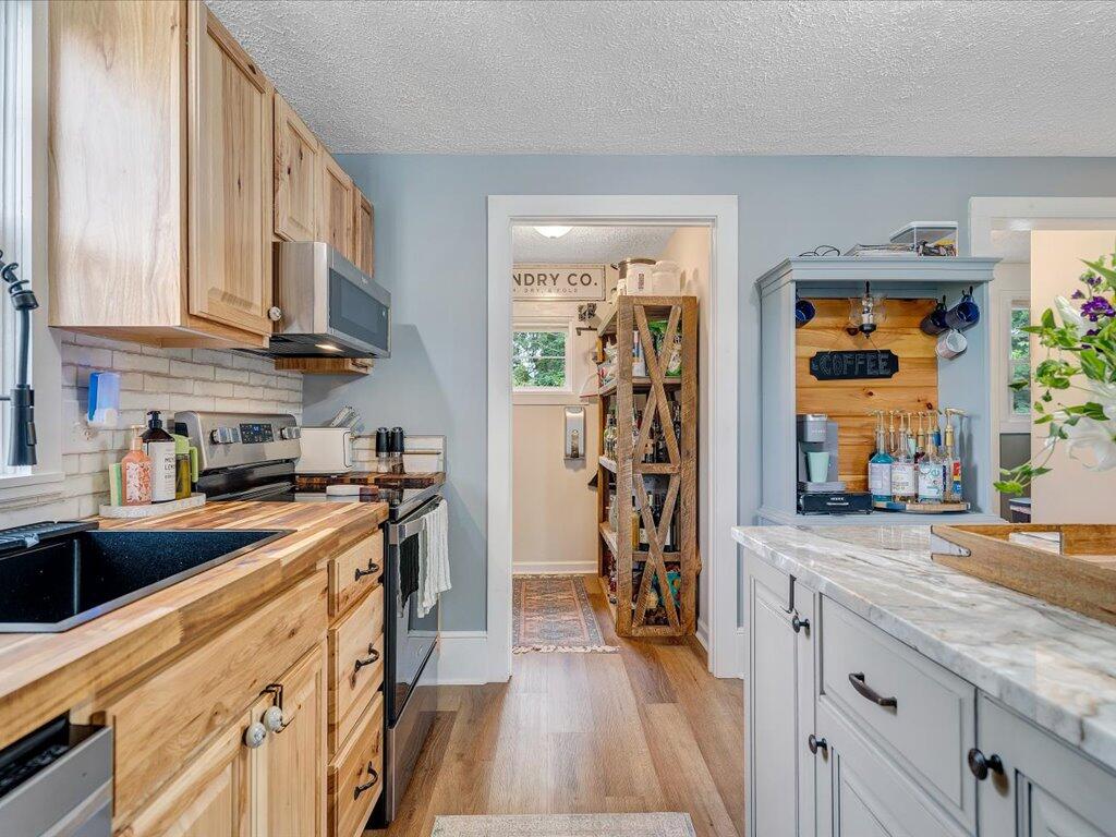 214 Spring Road Patrick Springs, VA 24133 - Photo 14 of 49 a kitchen with stainless steel appliances granite countertop a lot of counter top space and wooden floor