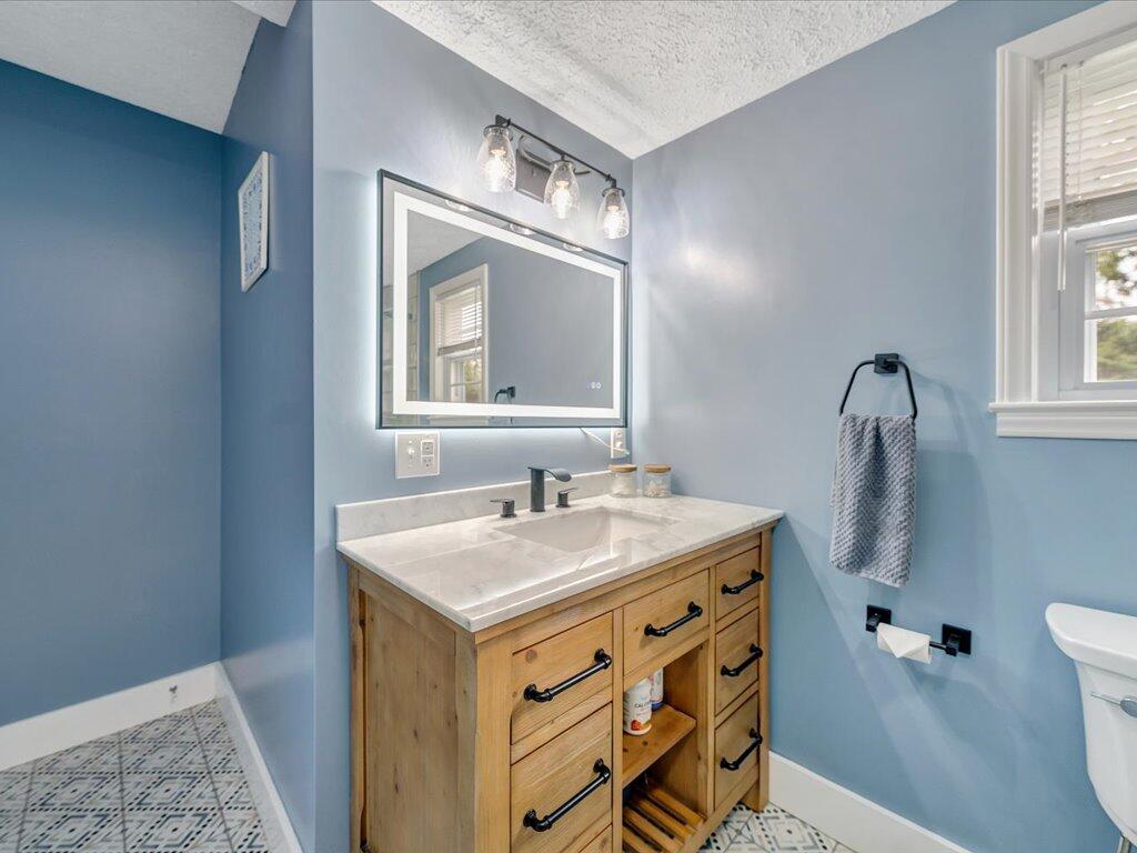 214 Spring Road Patrick Springs, VA 24133 - Photo 25 of 49 a bathroom with a granite countertop sink toilet and mirror