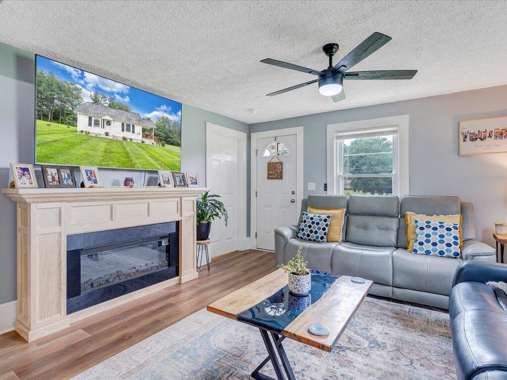214 Spring Road Patrick Springs, VA 24133 - Photo 7 of 49 a living room with furniture a fireplace and a flat screen tv