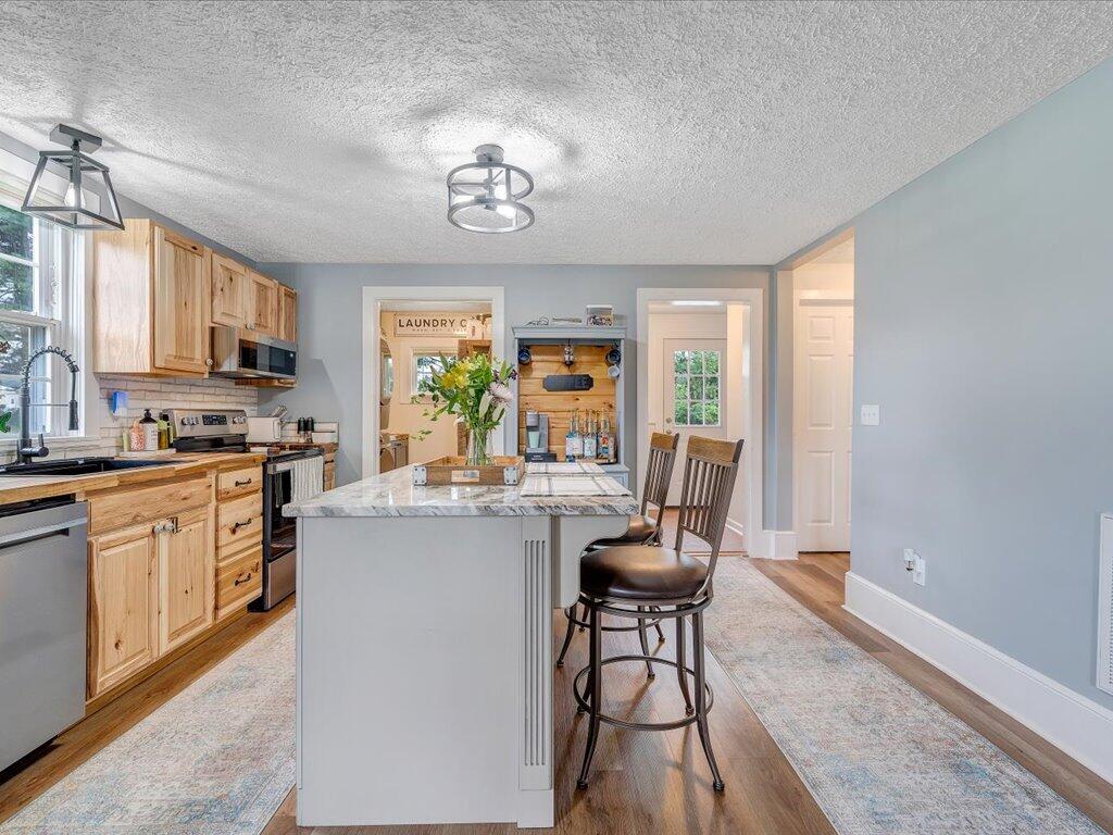 214 Spring Road Patrick Springs, VA 24133 - Photo 8 of 49 a kitchen with a dining table chairs and refrigerator