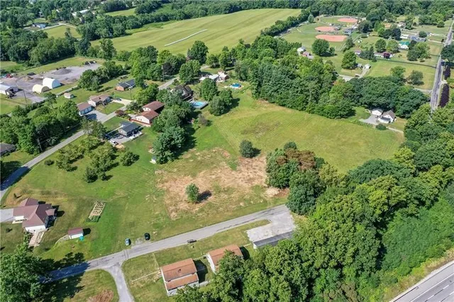 an aerial view of residential houses with outdoor space and trees