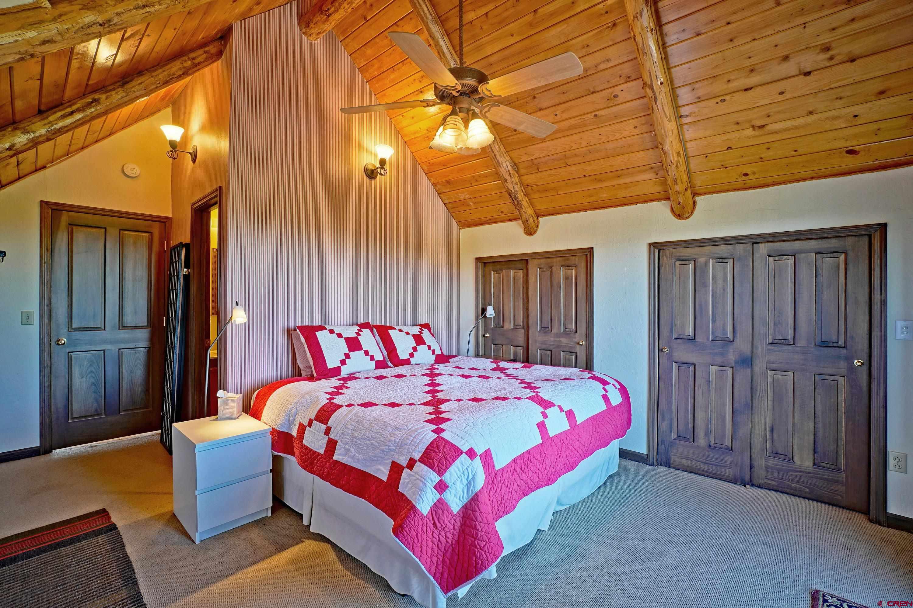 76 Tower Road South Ridgway, CO 81432 - Photo 21 of 37 a bedroom with a bed and a chandelier