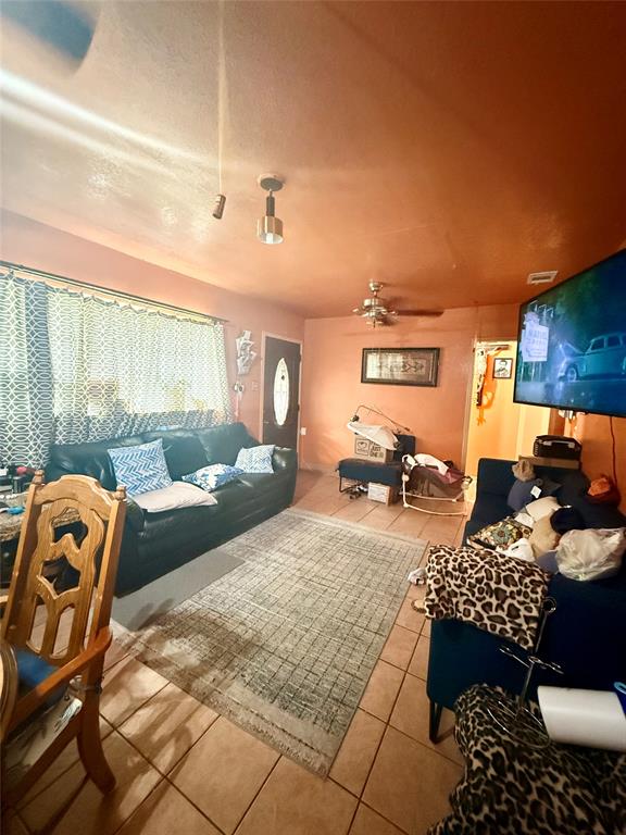 9918 Constance Street Dallas, TX 75220 - Photo 8 of 13 Living area featuring tile patterned flooring, ceiling fan, and a textured ceiling