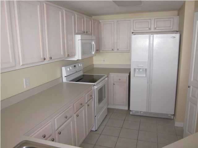 8600 East County Highway 30A, Unit 140 Seacrest, FL 32461 - Photo 7 of 16 a kitchen with white cabinets and white appliances
