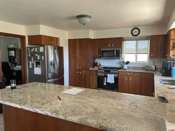 a kitchen with stainless steel appliances granite countertop a stove refrigerator and cabinets