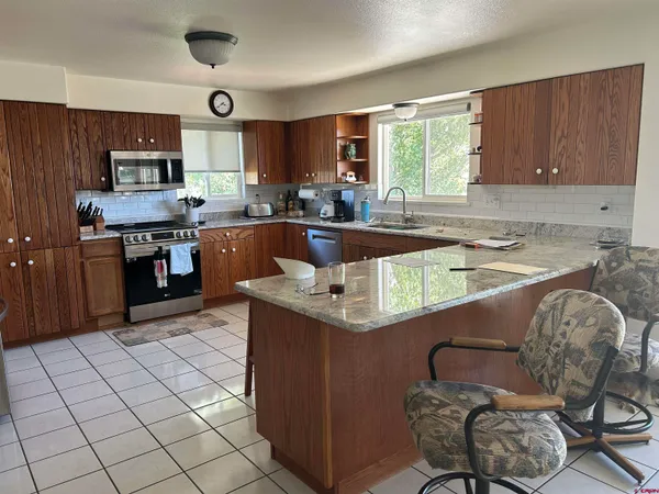 a kitchen with stainless steel appliances granite countertop a sink counter space cabinets and a window