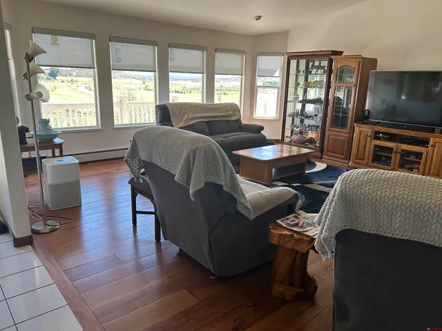 a living room with furniture a flat screen tv and a large window