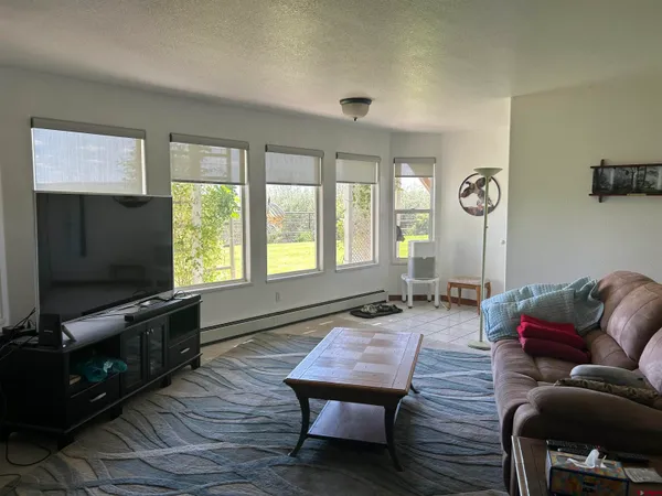 a living room with furniture a window and a flat screen tv