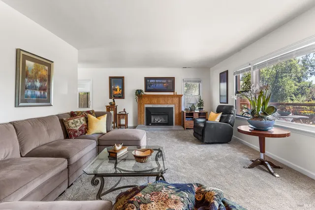 a living room with furniture fireplace and a large window