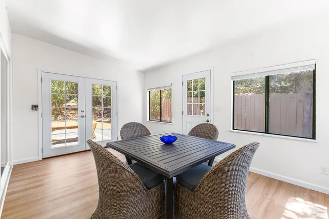 a living room with table chairs and wooden floor
