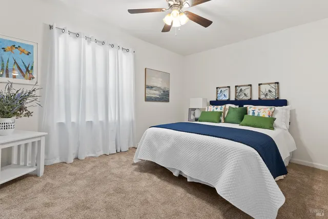 a bedroom with a bed and painting on the wall