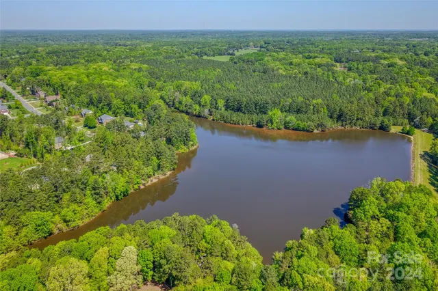 an aerial view of a house with a yard and lake view