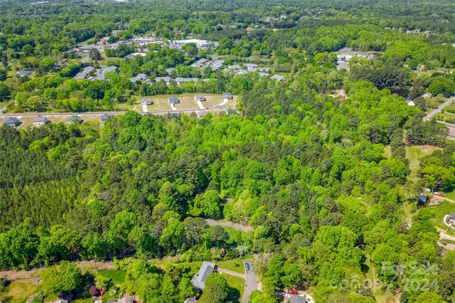 an aerial view of a houses with a lush green hillside