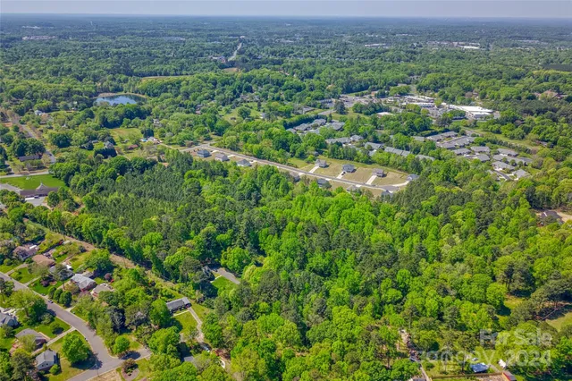 an aerial view of a houses with a lush green hillside