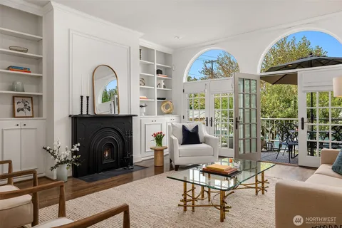 a living room with furniture fireplace and a large window