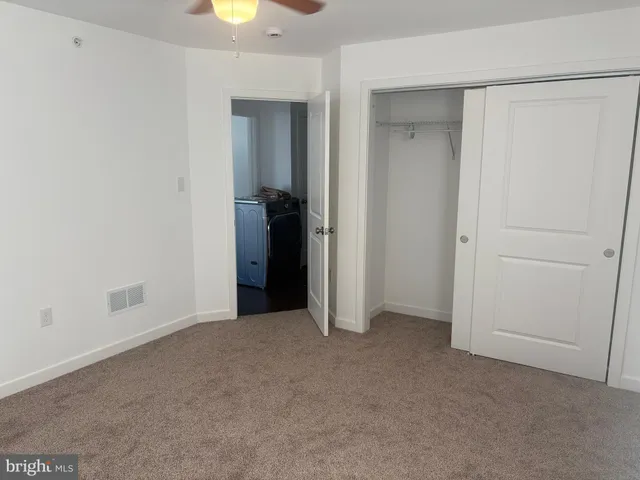 an empty room with closet and mirror