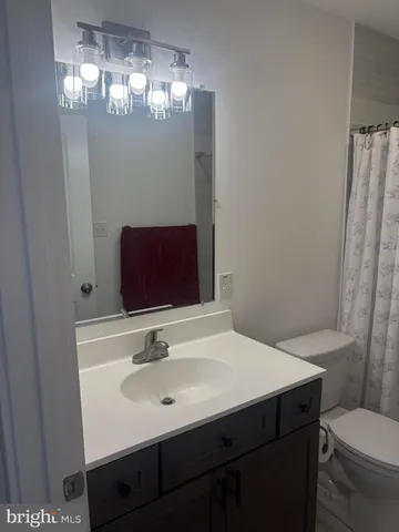 a bathroom with a sink toilet and mirror