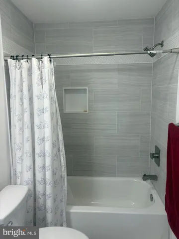 a bathroom with a shower curtain and a toilet