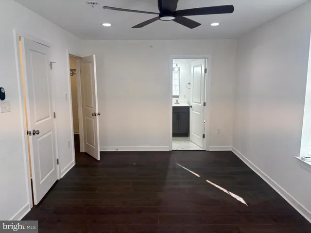 an empty room with wooden floor and a ceiling fan