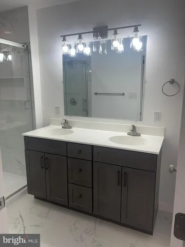 a bathroom with a double vanity sink mirror and lamp