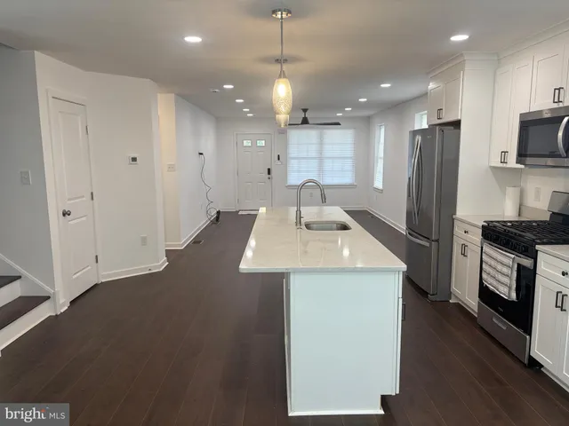a kitchen with kitchen island a sink stainless steel appliances and counter space