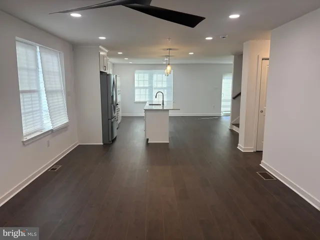 a view of a hallway with wooden floor and windows