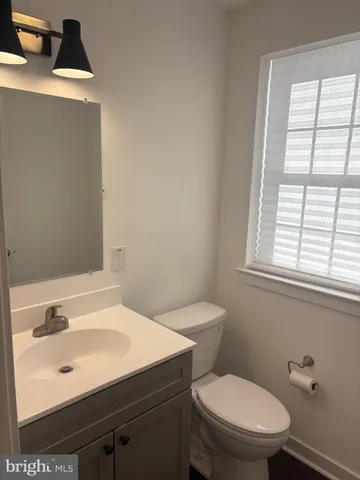 a bathroom with a sink a toilet and a window