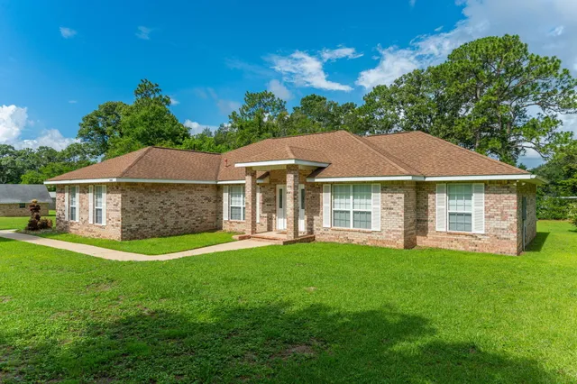 a view of a house with a yard and sitting area