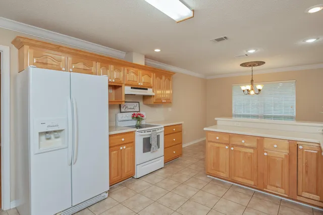 a kitchen with stainless steel appliances granite countertop a refrigerator and a stove