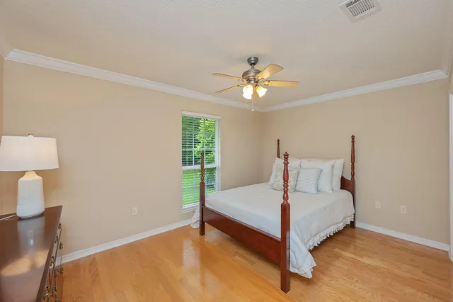 an empty room with a chandelier fan and windows