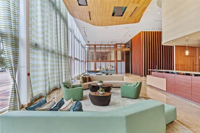 a living room with wooden floor and a large mirror
