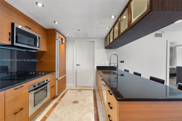 a kitchen with stainless steel appliances granite countertop a sink stove and refrigerator